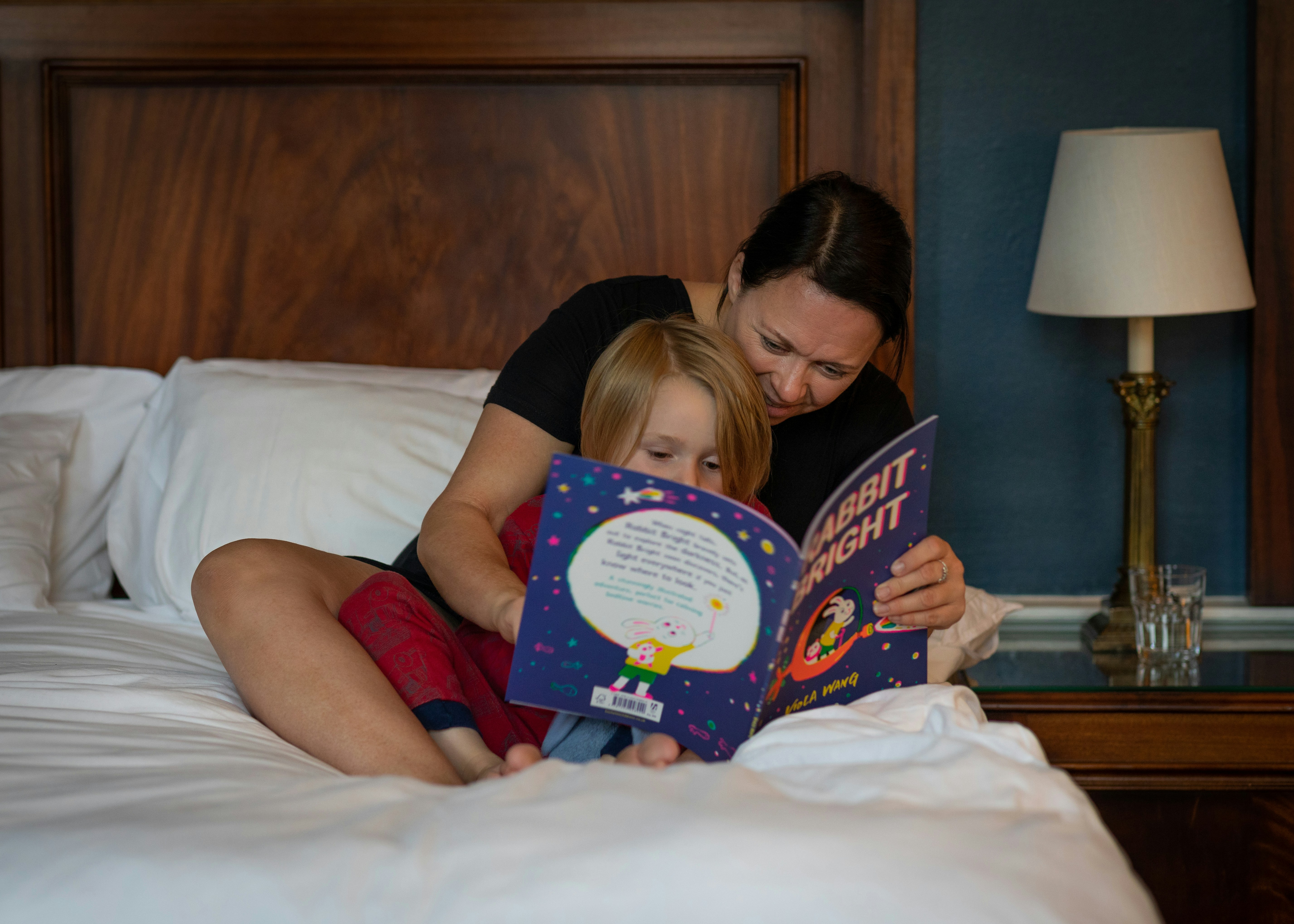 Padre leyendo un cuento para dormir a un niño en un entorno acogedor